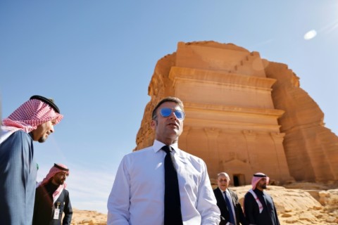 A world away from the crisis, French President Emmanuel Macron strolled through the desert sands of the Al-Ula oasis on a state visit to Saudi Arabia, marvelling at ancient landmarks