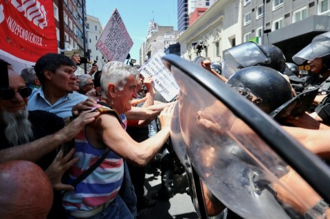 Pensioners and riot police scuffle during a protest outside the headquarters of the government agency that manages retiree benefits