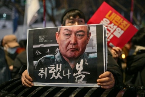 A protester holds a poster calling for the ouster of South Korean President Yoon Suk Yeol at a candlelight rally in Seoul