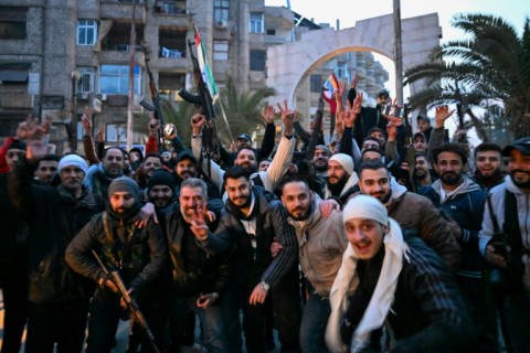 People celebrate in the Damascus suburb of Jaramana on Sunday