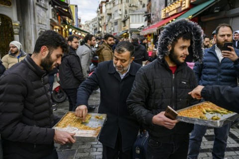 Syrians hand out baklavas in Istanbul to celebrate the reported fall of President Bashar al-Assad