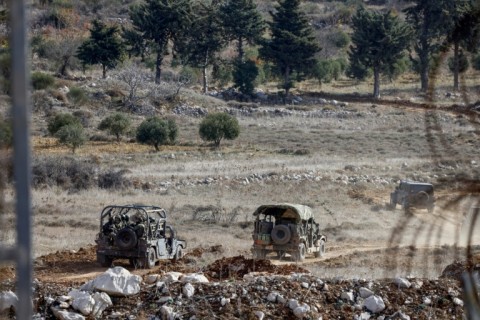 Israeli military vehicles are seen in the buffer zone on its border with Syria