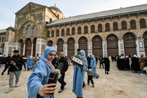 People gather at the courtyard of Dasmascus's eighth-century Umayyad Mosque, where rebel leader Abu Mohammed al-Jolani made an appearance after capturing the capital