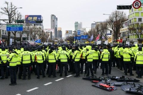 Police stand guard while blocking a road as demonstrators in Seoul call for the ouster of South Korea President Yoon Suk Yeol 