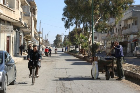 A Syrian man rides his bicycle down a street in the town of in Qusayr in Syria's central Homs province