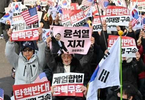 Supporters of impeached South Korean President Yoon Suk Yeol hold  placards during a protest  in Seoul