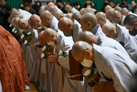 Buddhist monks pay their respects at a memorial altar for victims of the Jeju Air plane crash, at Muan Sports Park on December 30