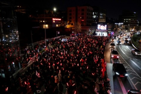 Supporters of deposed South Korean president Yoon Suk Yeol demonstrate near his residence brandishing glowsticks