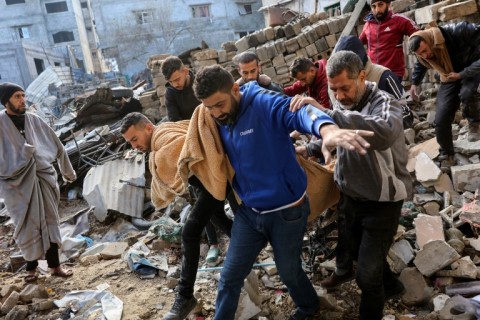 Palestinians carry a body after, according to Civil Defence rescuers, an Israeli strike on the al-Ghoula family home in the Gaza City area