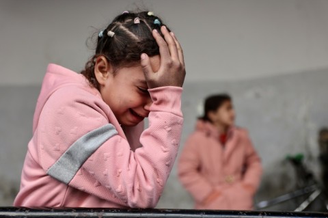 A Palestinian child mourns members of the al-Ghoula family, 11 of whose members including seven children were killed by an Israeli air strike, according to Civil Defence