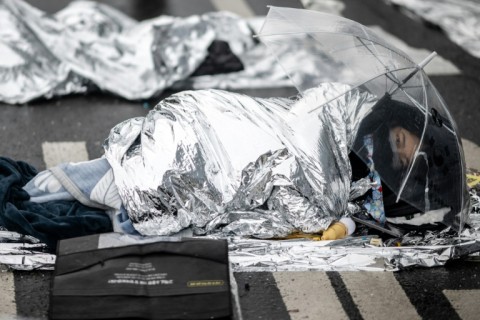 A demonstrator using thermal blankets rests during a rally against impeached South Korean President Yoon Suk Yeol