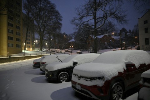 Cars are covered in snow during a winter storm in a residential area of Washington, DC, early on January 6, 2025