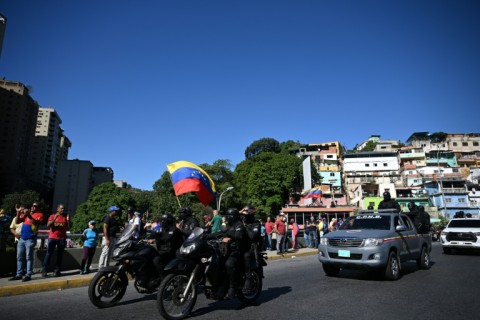 Motorbikes ride followed by a Bolivarian Guard van during a protest called by the opposition on the eve of the presidential inauguration, in Caracas on January 9, 2025