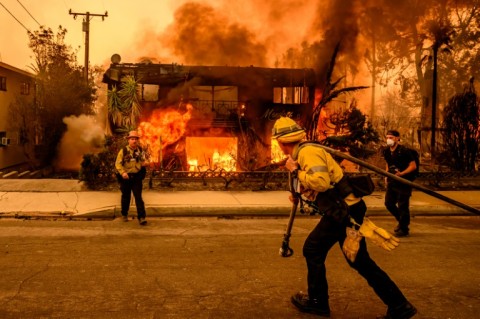 Firefighters work as an apartment building burns in the Altadena area of Los Angeles county