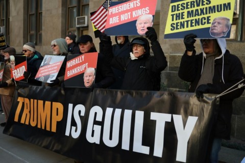 There was also a small vigil of anti-Trump demonstrators behind a hoarding reading 'Trump is guilty'