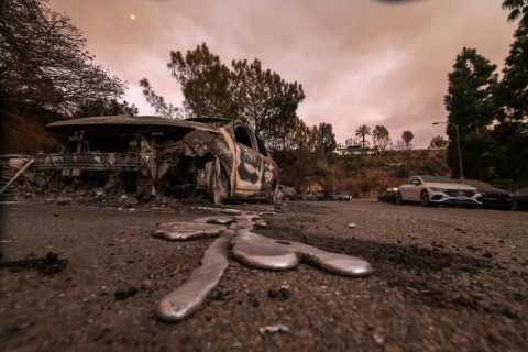 Molten metal flows from a car burnt out by the Palisades Fire in Los Angeles, California 