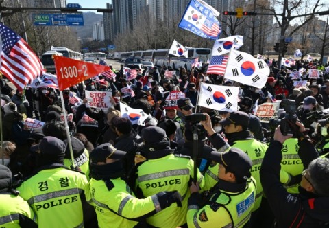 Supporters of impeached President Yoon Suk Yeol wave South Korea and the US flags as they gather outsidethe  Corruption Investigation Office