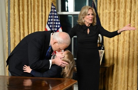 US President Joe Biden kisses his grand-son Beau Biden Jr. as First Lady Jill Biden gestures after the President delivered his farewell address to the nation from the Oval Office of the White House in Washington, DC, on January 15, 2025.