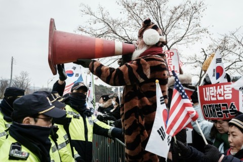 A supporter of detained and impeached South Korean President Yoon Suk Yeol holds up a safety cone during a rally at the entrance of the Seoul Detention Center