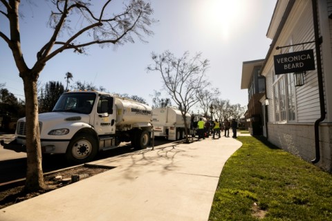 Privately operated water tankers stand ready near undamaged property in Pacific Palisades