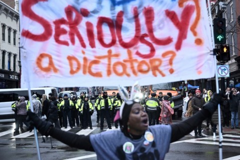 A protester chants as supporters wait in line to attend Donald Trump's victory rally in Washington