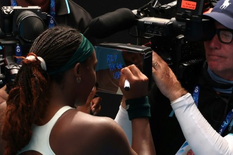 Coco Gauff writes the message 'RIP TikTok USA' on the camera following her victory over Switzerland's Belinda Bencic at the Australian Open 