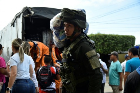 A police officer unloads humanitarian aid for displaced people in Tibu, Colombia