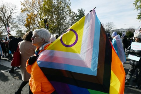 People hold LGBTQ+ flags outside the US Supreme Court