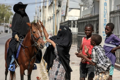 Children and curious passersby followed Muse as she rode through downtown Mogadishu