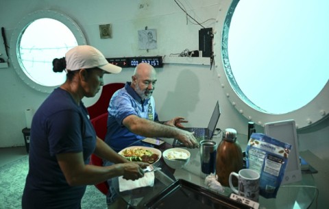 Rudiger Koch has breakfast in his underwater home before emerging as a world record holder