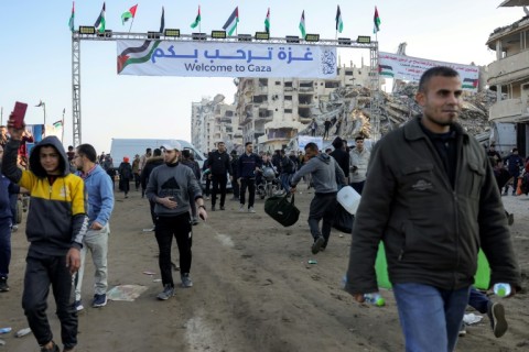 People in Gaza City wait for returning displaced Palestinians who have crossed the Netzarim Corridor, which had been blocked in a dispute between Israel and Hamas