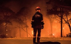 A firefighter stands during operations to put out a forest fire.