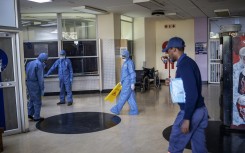 Workers wearing protective clothing clean an entrance hall of the Charlotte Maxeke Hospital in Johannesburg.