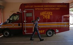 Members of the Tshwane Special Infection Unit on COVID-19 coronavirus walks past the Infectious Unit Ambulance during their demonstration exercise at the Hatfield Emergency Station in Pretoria on May 4, 2020.