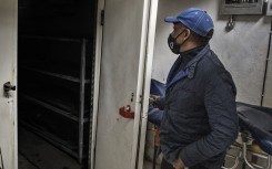 Sello Headbush, the owner of a Funeral Parlourh opens the door of his cold storage facility to check the situation during a load shedding in Port Elizabeth on July 11, 2020.