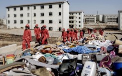 Members of the Red Ants stand next to personal belongings of people they removed from the apartments during a joint eviction operation between the Red Ants and the South African Police Service (SAPS) of people that illegally occupied apartment buildings in Roodepoort, near Johannesburg.