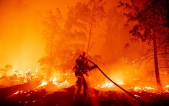 A firefighter douses flames as they push towards homes during the Creek fire in the Cascadel Woods area of unincorporated Madera County, California on September 7, 2020. 