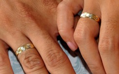 File: A couple holding hands during a wedding.