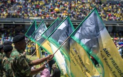 Soldiers hold banners bearing portraits of the former and current ANC presidents during the African National Congress's 106th-anniversary celebrations held at Absa Stadium in East London on January 13, 2018.