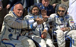 US space tourist Dennis Tito (L) shakes hands with his crew members Talgat Musabayev (C) and Yuri Baturin (R) after their landing near the Kazakh town of Arkalyk (some 300 km from Astana), 06 May 2001