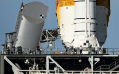 Engineers work on the Tail Service Mast Umbilical of the Artemis I unmanned lunar rocket as it sits on launch pad 39B at NASA's Kennedy Space Center