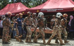 Rescue workers scoured muddy terrain for survivors and bodies as the death toll from a landslide at a Malaysian campsite rose to 24