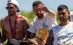 Lionel Messi (centre) celebrates Argentina's World Cup victory alongside team-mates Rodrigo de Paul (left) and Cristian Romero (right) in Buenos Aires before Christmas