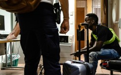 Border force police search a passenger boarding a flight from Cayenne, French Guiana