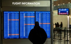 A traveler looks at a display listing cancelled and delayed flights at Ronald Reagan National Airport in Virginia on January 11, 2023