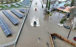 Cars driving through a flooded roadway in Planada, California, as an "atmospheric river" continues on January 10, 2023