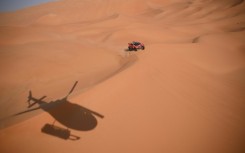 Sebastien Loeb and Belgian co-driver Fabian Lurquin steer their BRX to victory tracked by a helicopter in Saudi Arabia's Empty Quarter