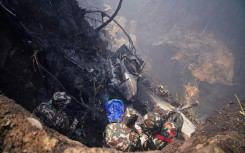 Rescuers inspect the site of a plane crash in Pokhara, Nepal