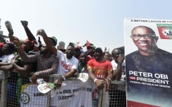 Supporters chant party slogans next to a banner of the candidate of the Labour Party Peter Obi during a campaign rally of the party in Lagos, on February 11, 2023.