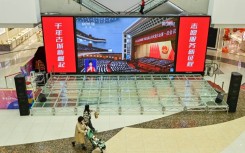 Live coverage of the opening session of the National People's Congress (NPC) is shown at a shopping mall in Qingzhou, China